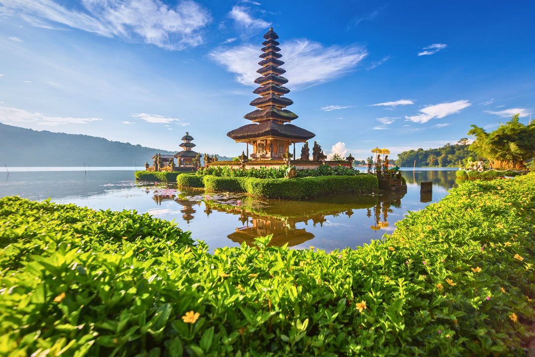 Det smukke hinduistiske tempel Pura Ulun Danu Bratan ligger i en sø omgivet af grøn natur på Bali.